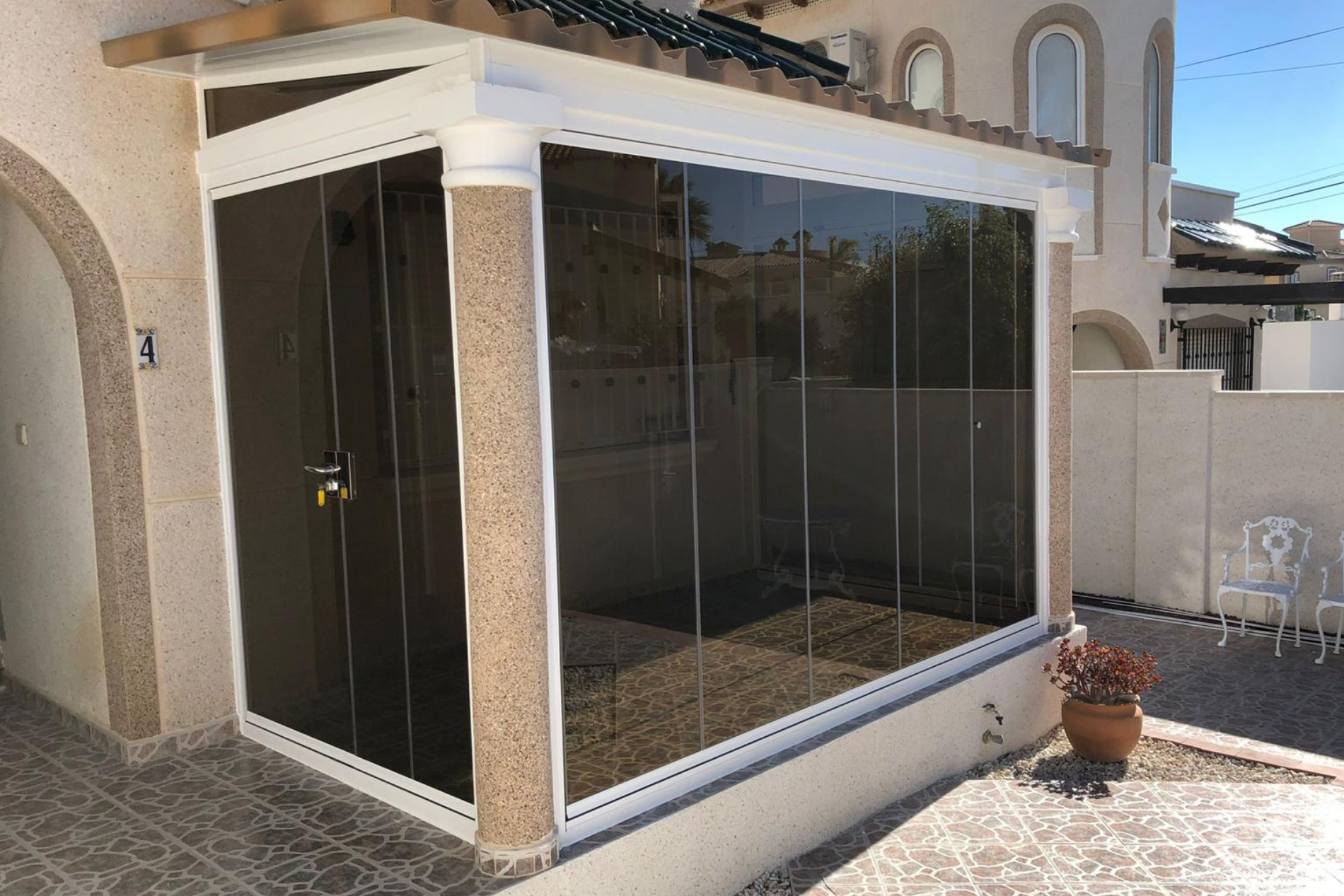 Compact floor to ceiling tinted window conservatory.