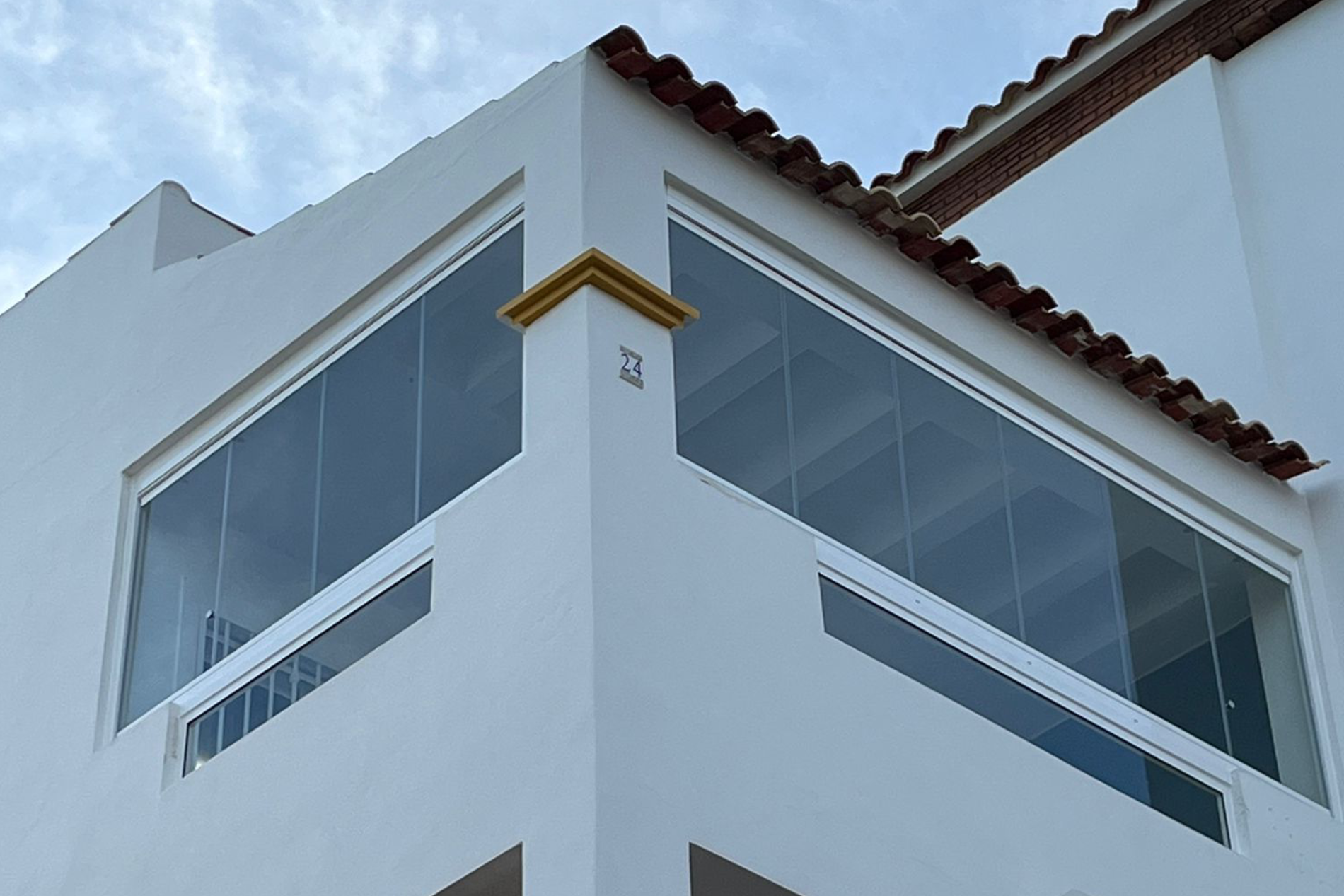 Photo taken looking up at top floor windows at front and side.